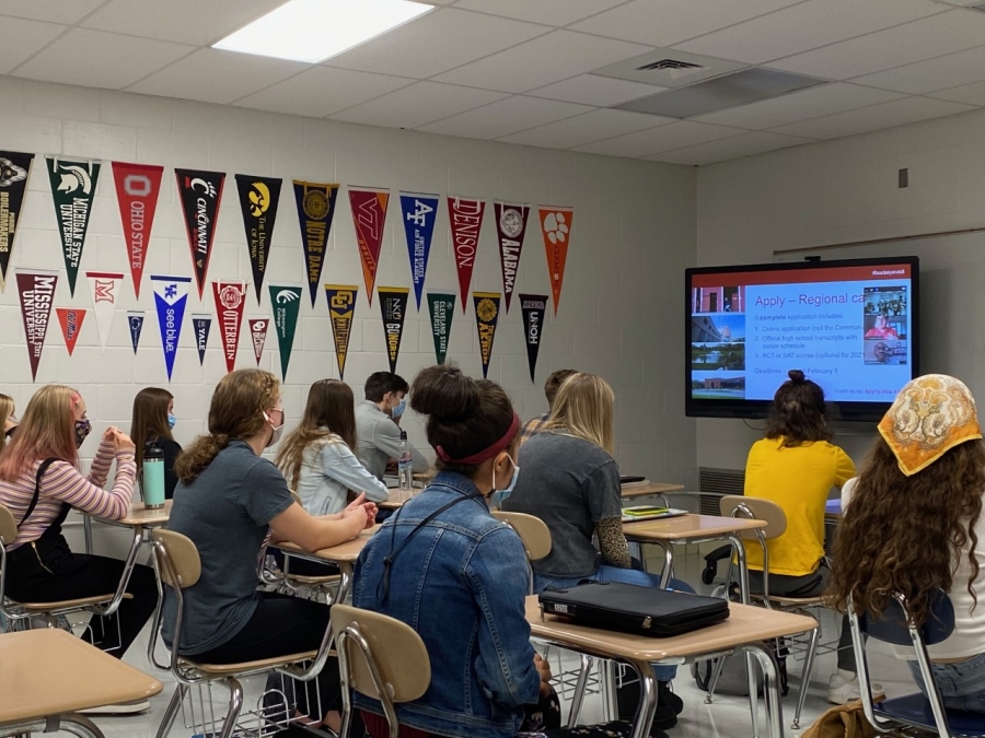 students watching a tv on a wall